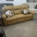 Front view of the Ashley Kanlow reclining sofa in honey yellow chenille fabric with track arms.