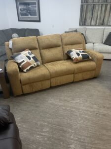 Front view of the Ashley Kanlow reclining sofa in honey yellow chenille fabric with track arms.